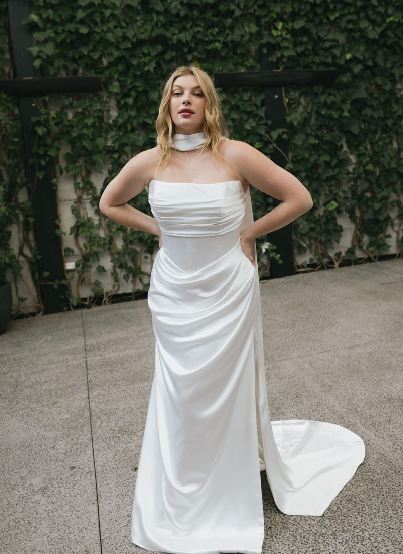 Plus size model wearing a fitted satin wedding dress by hera couture