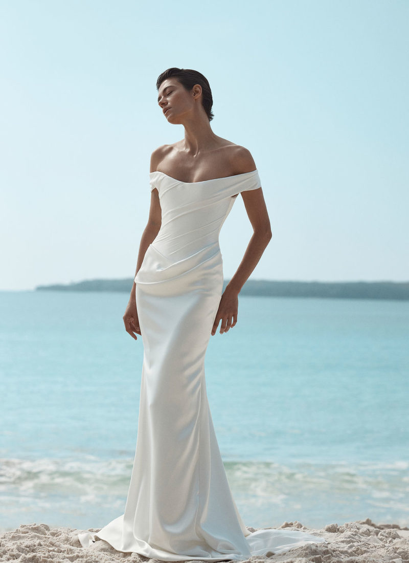 Model wearing a modern off shoulder wedding dress by KYHA